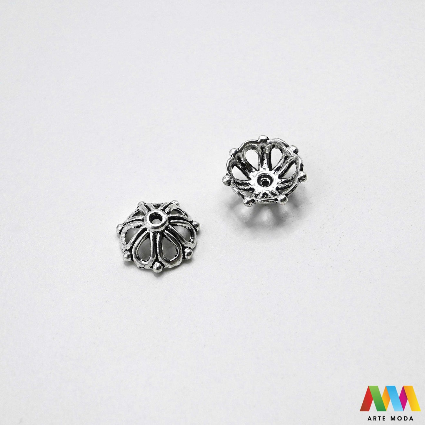 Luksuzne metalne filigranske ljevane kapice za perle u srebrnoj zlatnoj i brončanoj boji izložene Prikazane su čvrste i detaljno lijevane ornamentne kapice krunice i zvonoliki ukrasi koji obujmljuju okrugle staklene drvene i kamene perle pri izradi nakita Vrhunski metalni repromaterijal i masivniji dekorativni razdjelnici s preciznim rupama za nizanje namijenjeni za izradu unikatnih ogrlica narukvica i visećih naušnica u DIY radionicama za ručnu izradu modnog i vintage nakita arte moda repromaterijali